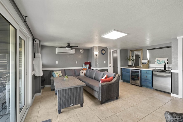 living room with beverage cooler, ceiling fan, a textured ceiling, a wall mounted AC, and light tile patterned flooring