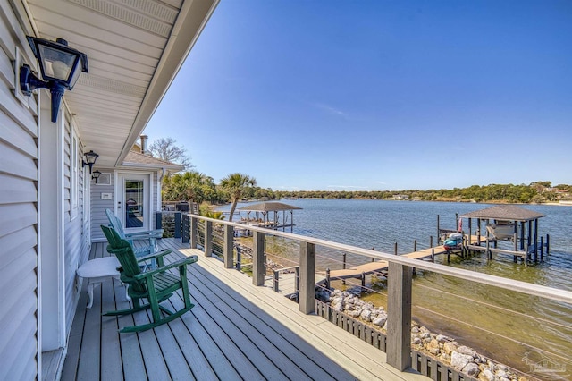 wooden terrace with a water view and a boat dock