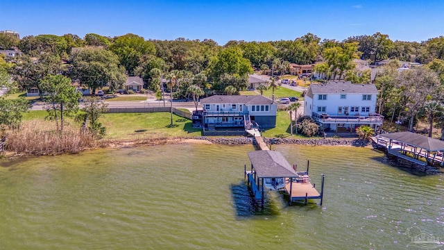 view of dock with a water view, a yard, and boat lift