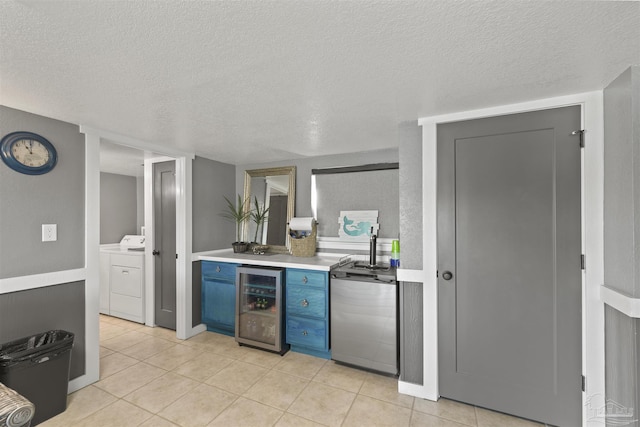 kitchen featuring dishwasher, wine cooler, blue cabinets, light countertops, and a textured ceiling