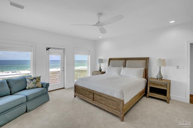 bedroom featuring light carpet, a water view, access to exterior, and ceiling fan