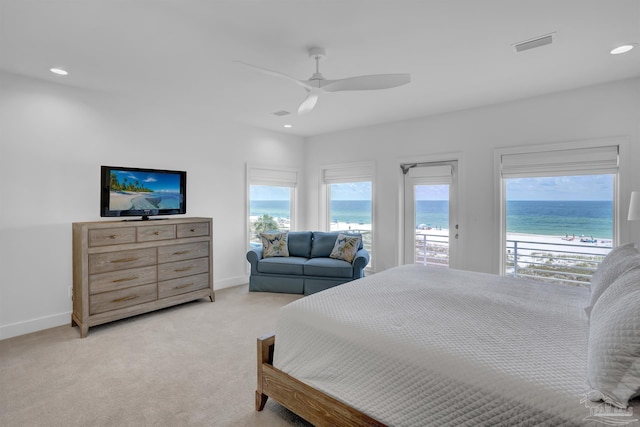 carpeted bedroom featuring access to outside, ceiling fan, and a water view