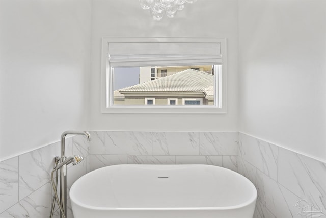 bathroom with a bathing tub and tile walls