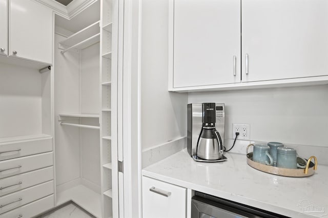 walk in closet with light tile patterned floors