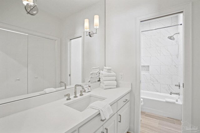 full bathroom with vanity, tiled shower / bath, and toilet