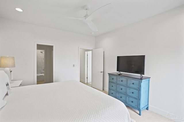 bedroom featuring light colored carpet, ensuite bathroom, and ceiling fan