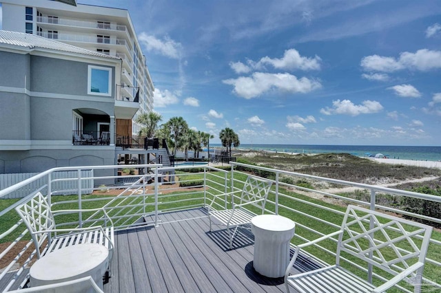 wooden deck with a yard and a water view