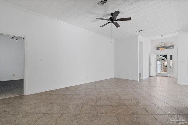 unfurnished room with ceiling fan, ornamental molding, a textured ceiling, and light tile patterned flooring