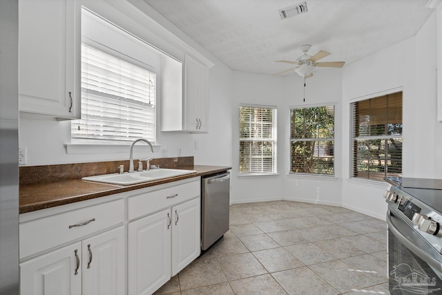 kitchen featuring stainless steel appliances, white cabinetry, sink, and light tile patterned flooring