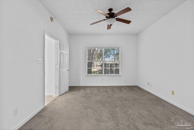 carpeted empty room featuring ceiling fan and a textured ceiling