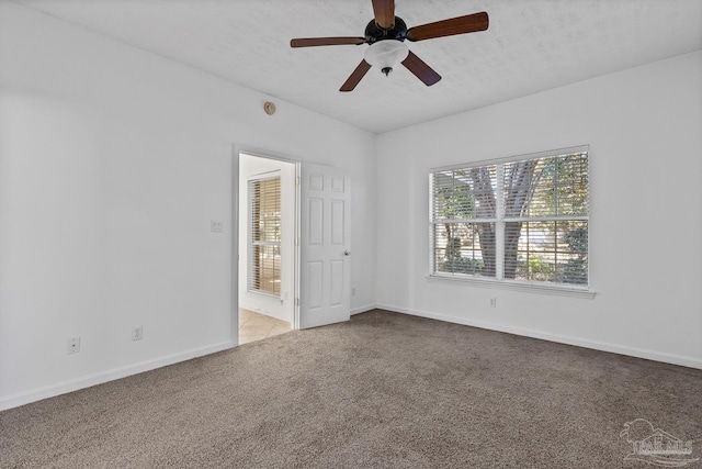 spare room featuring light colored carpet and ceiling fan