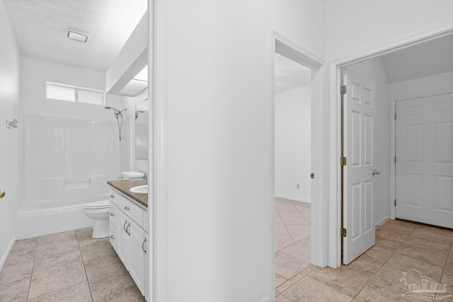 full bathroom featuring tile patterned floors, toilet,  shower combination, a textured ceiling, and vanity