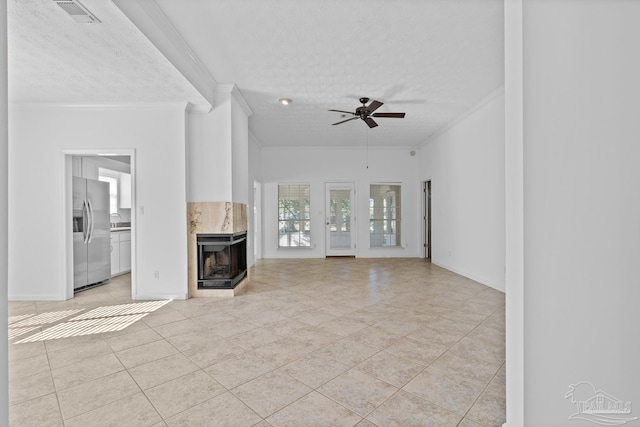 unfurnished living room with a premium fireplace, ornamental molding, light tile patterned flooring, and a textured ceiling