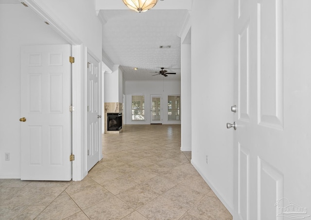 hall featuring light tile patterned flooring and ornamental molding