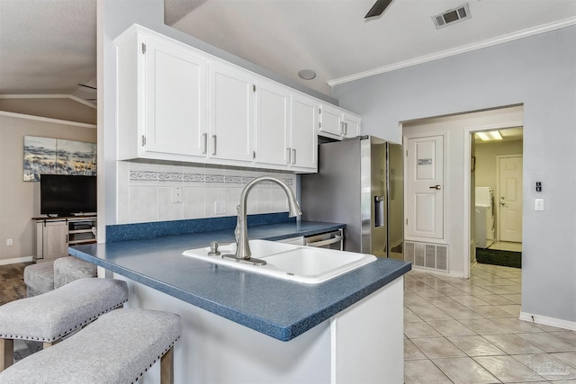 4122 Cobia St, Pensacola, FL 32507 - kitchen with ornamental molding, dark countertops, white cabinetry, baseboards, and stainless steel fridge with ice dispenser