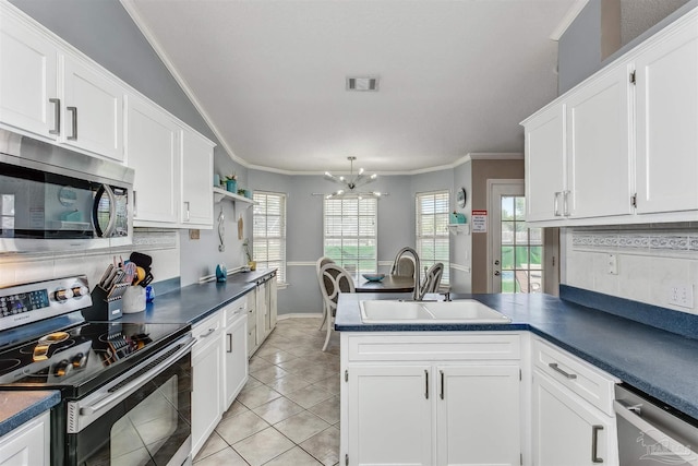 4122 Cobia St, Pensacola, FL 32507 - kitchen with stainless steel appliances, a sink, a peninsula, dark countertops, and white cabinets