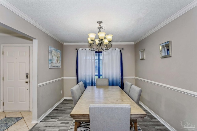 4122 Cobia St, Pensacola, FL 32507 - dining area with a chandelier, a textured ceiling, crown molding, baseboards, and wood finished floors