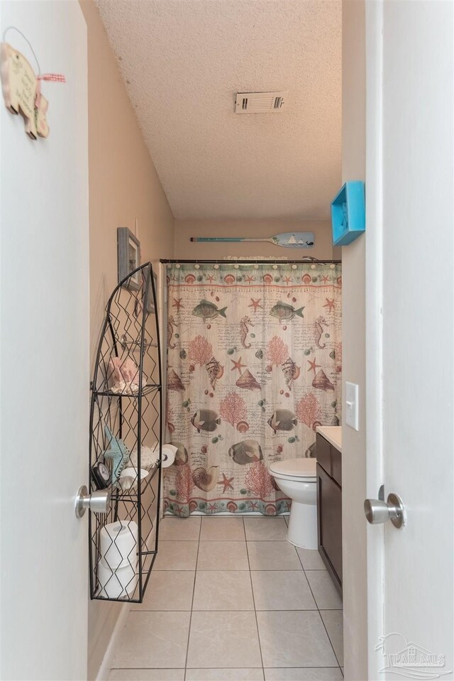 bathroom with visible vents, toilet, tile patterned flooring, a textured ceiling, and vanity