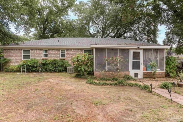 back of house featuring a yard, brick siding, cooling unit, and a sunroom