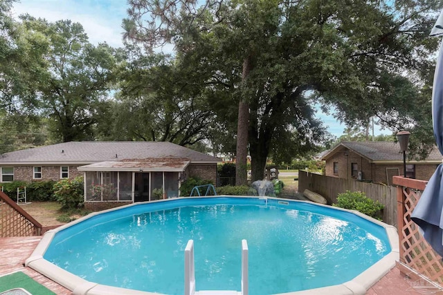 view of swimming pool featuring fence, a sunroom, and a fenced in pool