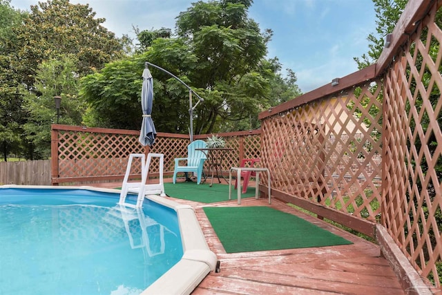 view of swimming pool featuring a fenced in pool, fence, and a wooden deck