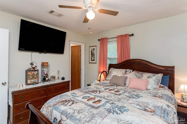 bedroom with visible vents, ceiling fan, and a textured ceiling