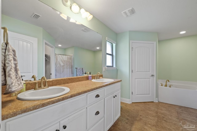 bathroom featuring visible vents, a bath, double vanity, and a sink