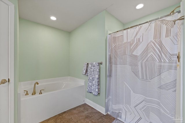 bathroom with baseboards, recessed lighting, and a bath