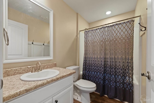 full bath with toilet, wood finished floors, and vanity