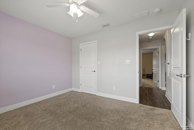 unfurnished bedroom featuring baseboards, visible vents, ceiling fan, and carpet