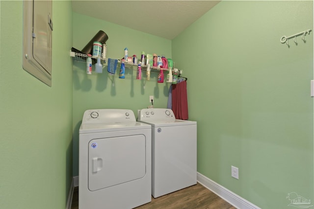 laundry area with washer and clothes dryer, electric panel, laundry area, baseboards, and wood finished floors