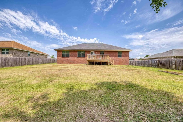 rear view of house featuring brick siding, a fenced backyard, and a yard