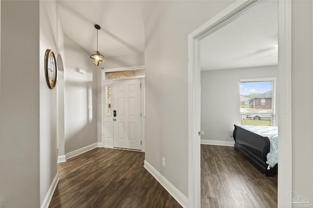 foyer entrance with dark wood-style floors and baseboards