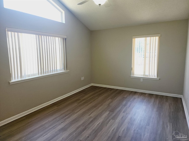 spare room featuring vaulted ceiling, a textured ceiling, ceiling fan, and dark hardwood / wood-style flooring