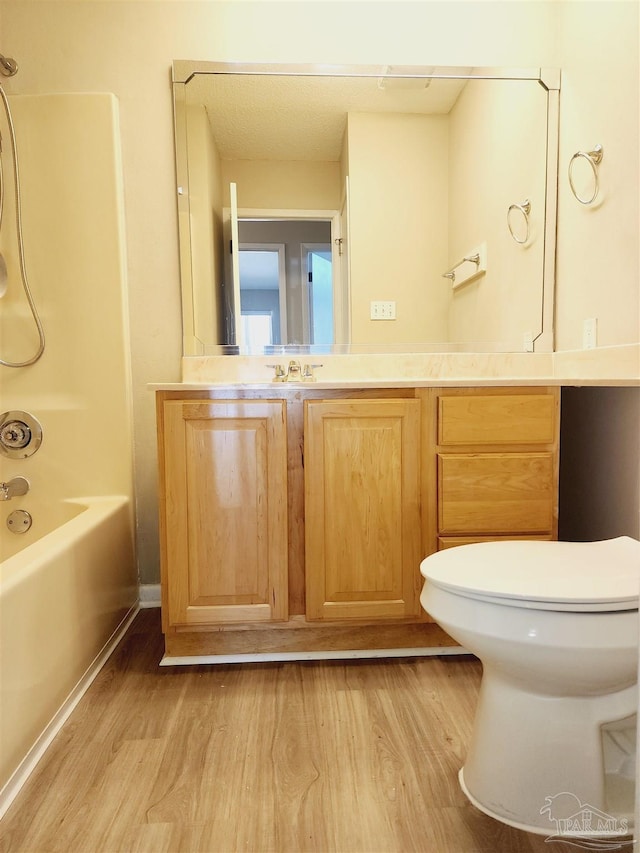 full bathroom featuring vanity, wood-type flooring, toilet, and shower / bath combination