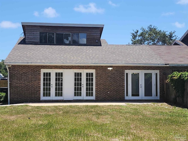 rear view of house featuring french doors and a lawn