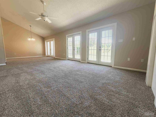 carpeted empty room with french doors, ceiling fan, vaulted ceiling, and a textured ceiling