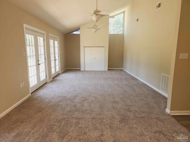 carpeted spare room featuring vaulted ceiling and ceiling fan