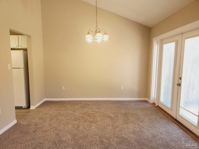 unfurnished room featuring lofted ceiling, carpet floors, a notable chandelier, and french doors