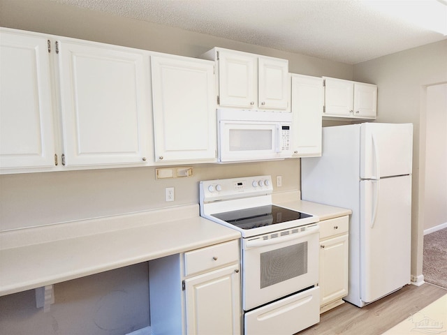 kitchen featuring white appliances, light hardwood / wood-style flooring, a textured ceiling, and white cabinets