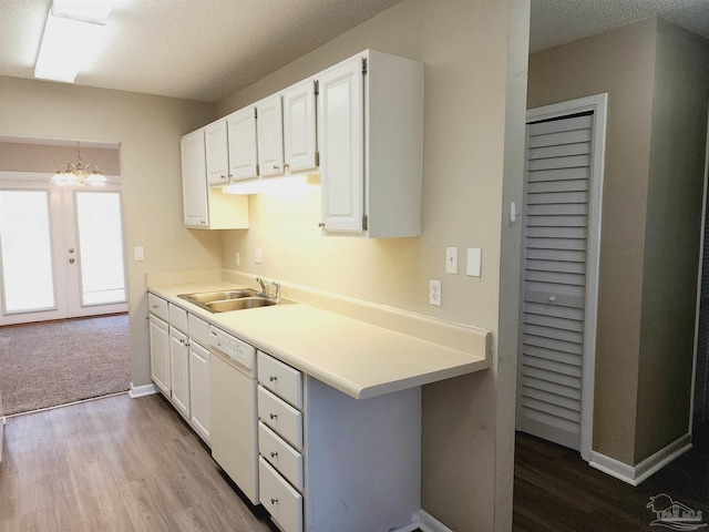 kitchen featuring pendant lighting, sink, light hardwood / wood-style flooring, dishwasher, and white cabinetry