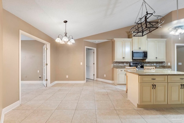7850 Amethyst Dr, Pensacola, FL 32506 - kitchen featuring appliances with stainless steel finishes, decorative backsplash, cream cabinets, lofted ceiling, and baseboards