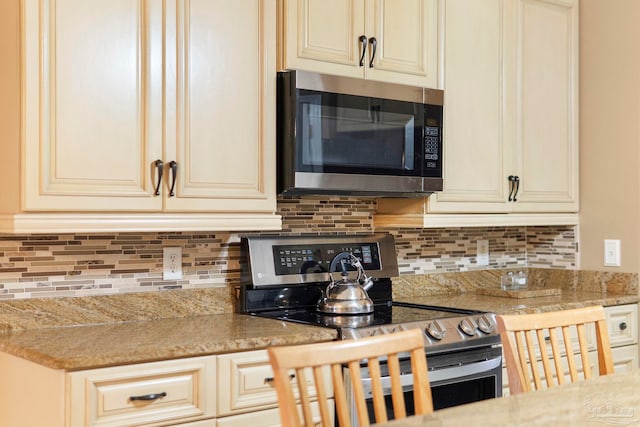 7850 Amethyst Dr, Pensacola, FL 32506 - kitchen featuring appliances with stainless steel finishes, cream cabinetry, and tasteful backsplash