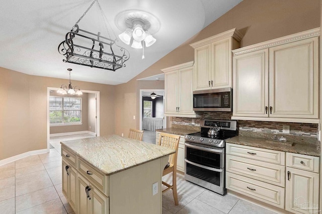 7850 Amethyst Dr, Pensacola, FL 32506 - kitchen featuring stainless steel appliances, cream cabinetry, ceiling fan, tasteful backsplash, and lofted ceiling