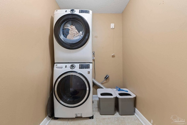 7850 Amethyst Dr, Pensacola, FL 32506 - laundry area featuring estacked washer and dryer, baseboards, light tile patterned floors, and a textured ceiling