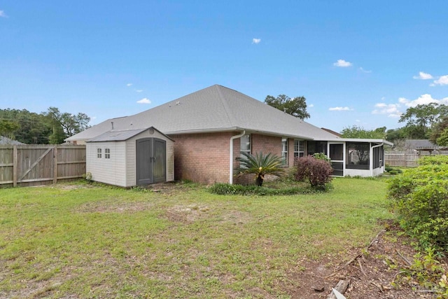 7850 Amethyst Dr, Pensacola, FL 32506 - rear view of house featuring a sunroom, a storage shed, brick siding, and an outdoor structure