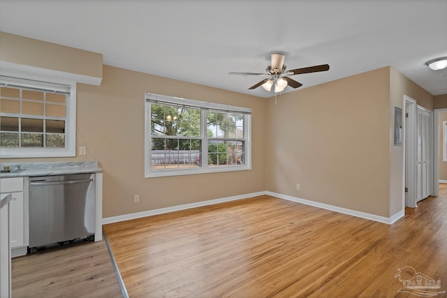 unfurnished dining area with baseboards, light wood-type flooring, and ceiling fan