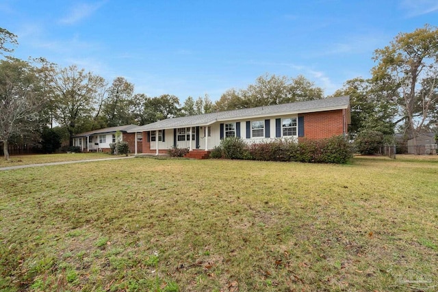 ranch-style house with a front yard and brick siding