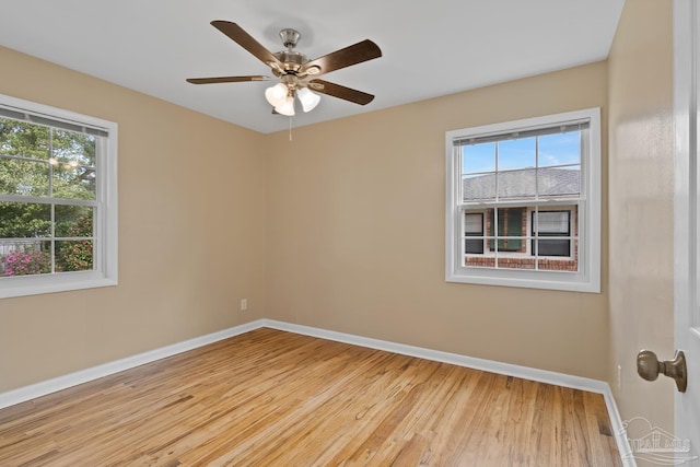 spare room featuring light wood-style flooring, a ceiling fan, and baseboards