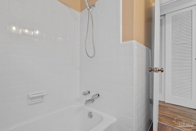 bathroom with bathing tub / shower combination and wood finished floors